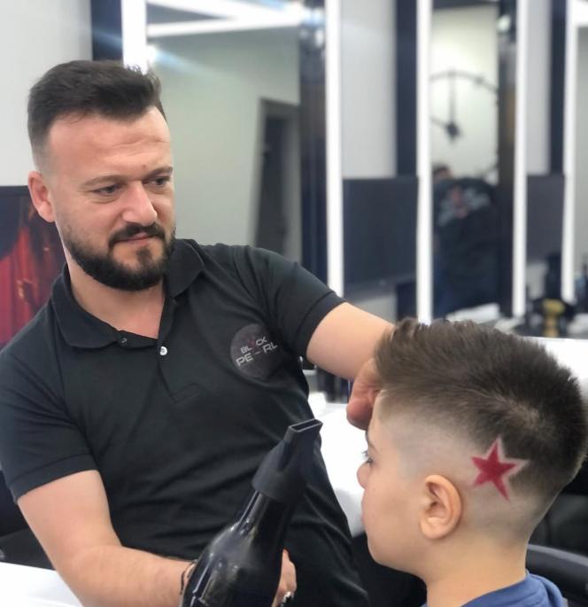 Çocuk müşterinin saçına makineyle yıldız deseni işleniyor